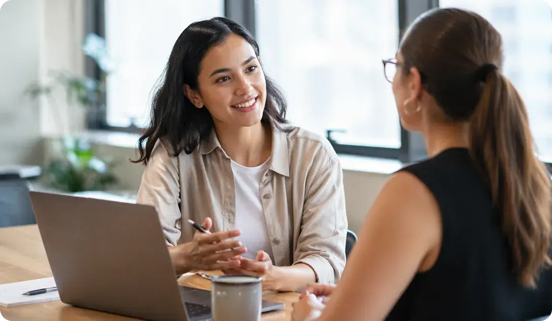 Two people in an intro session at a table with a laptop