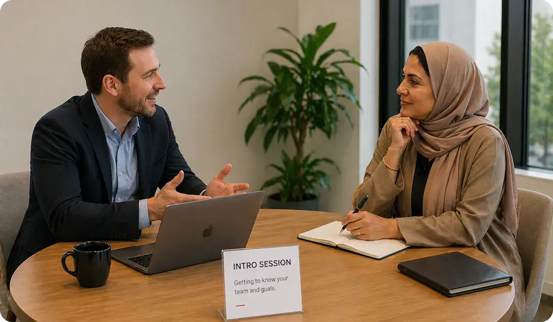 Two people in an intro session at a table with a laptop